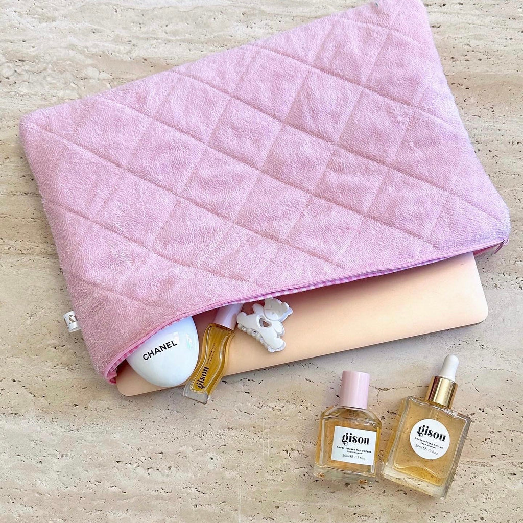 Pink terrycloth gingham-style pouch laid flat, quilted texture with zipper edge visible.
