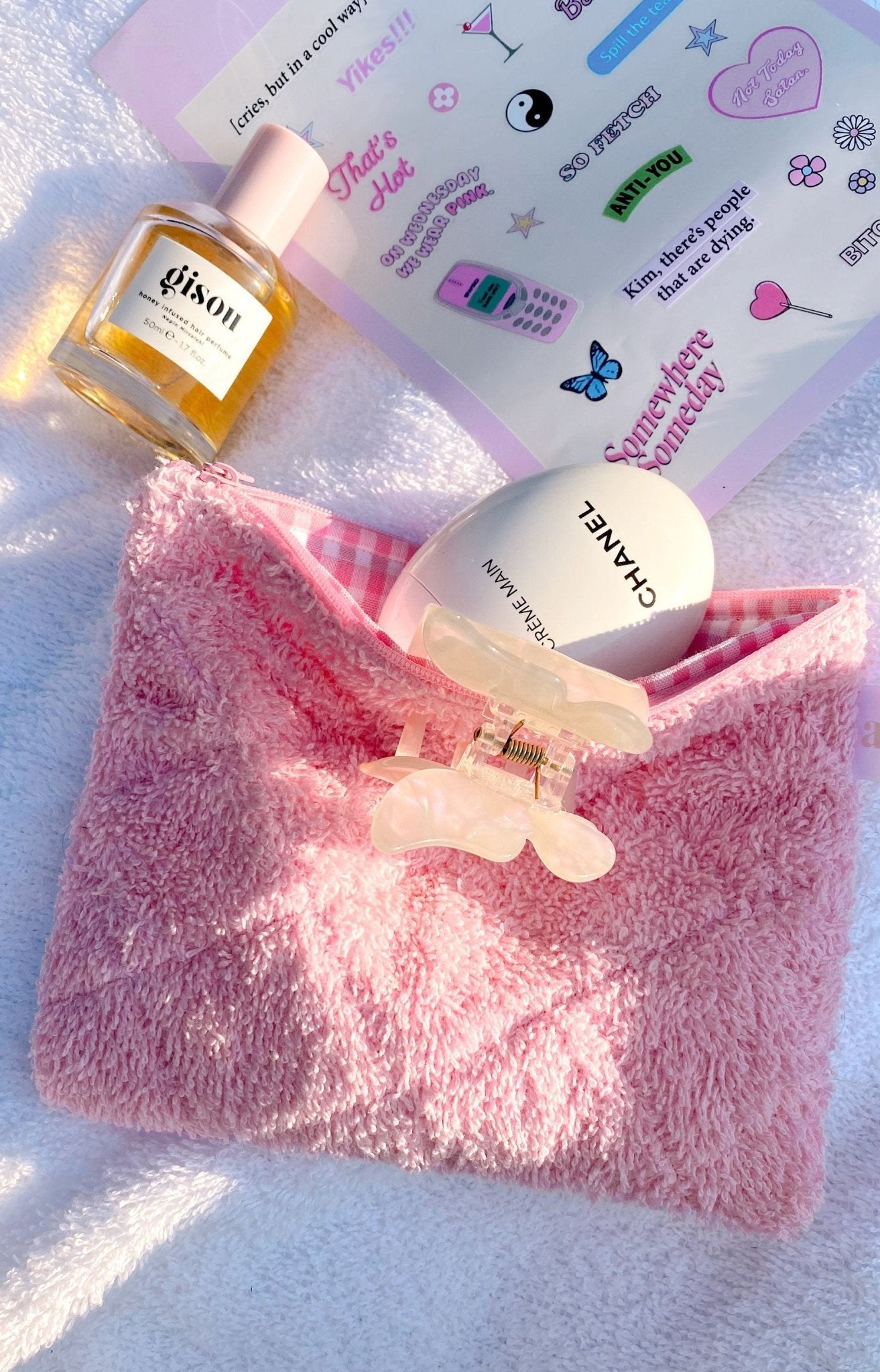 Pink terrycloth gingham pouch with zipper, toiletries filling the open case