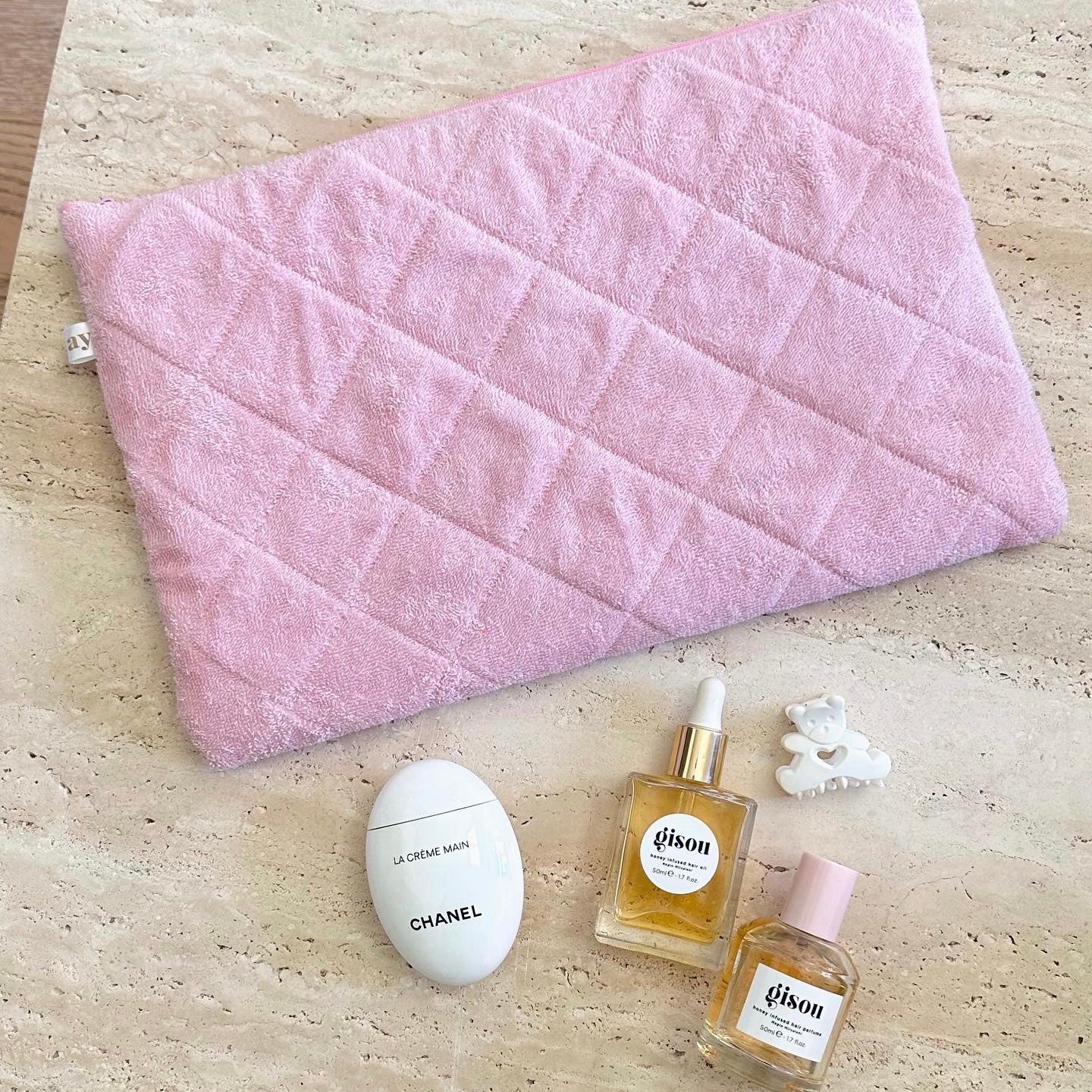 Pink terrycloth pouch with quilted panels and zipper, folded and shown from above.