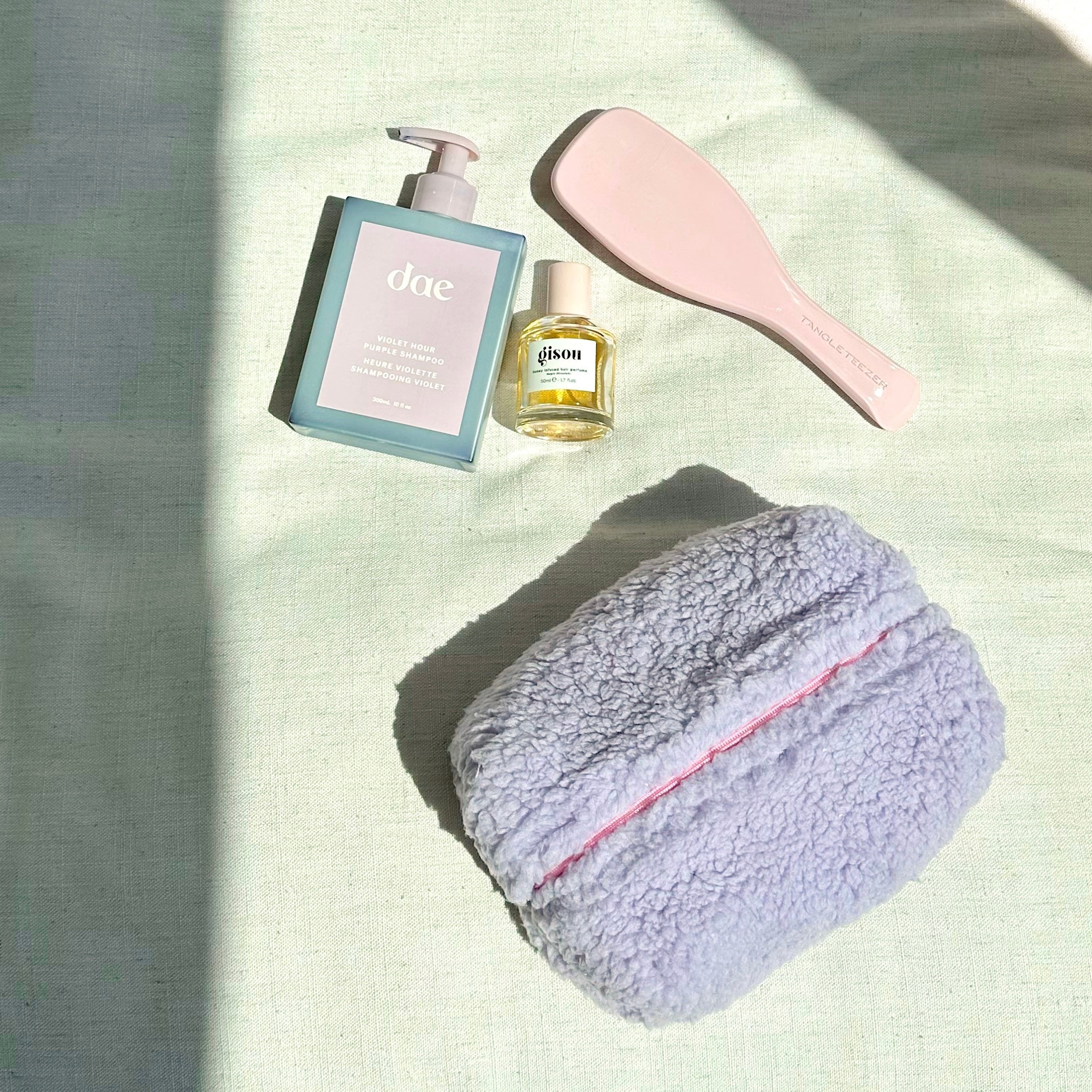 Lavender soft teddy toiletry pouch with pink zipper stripe across the top