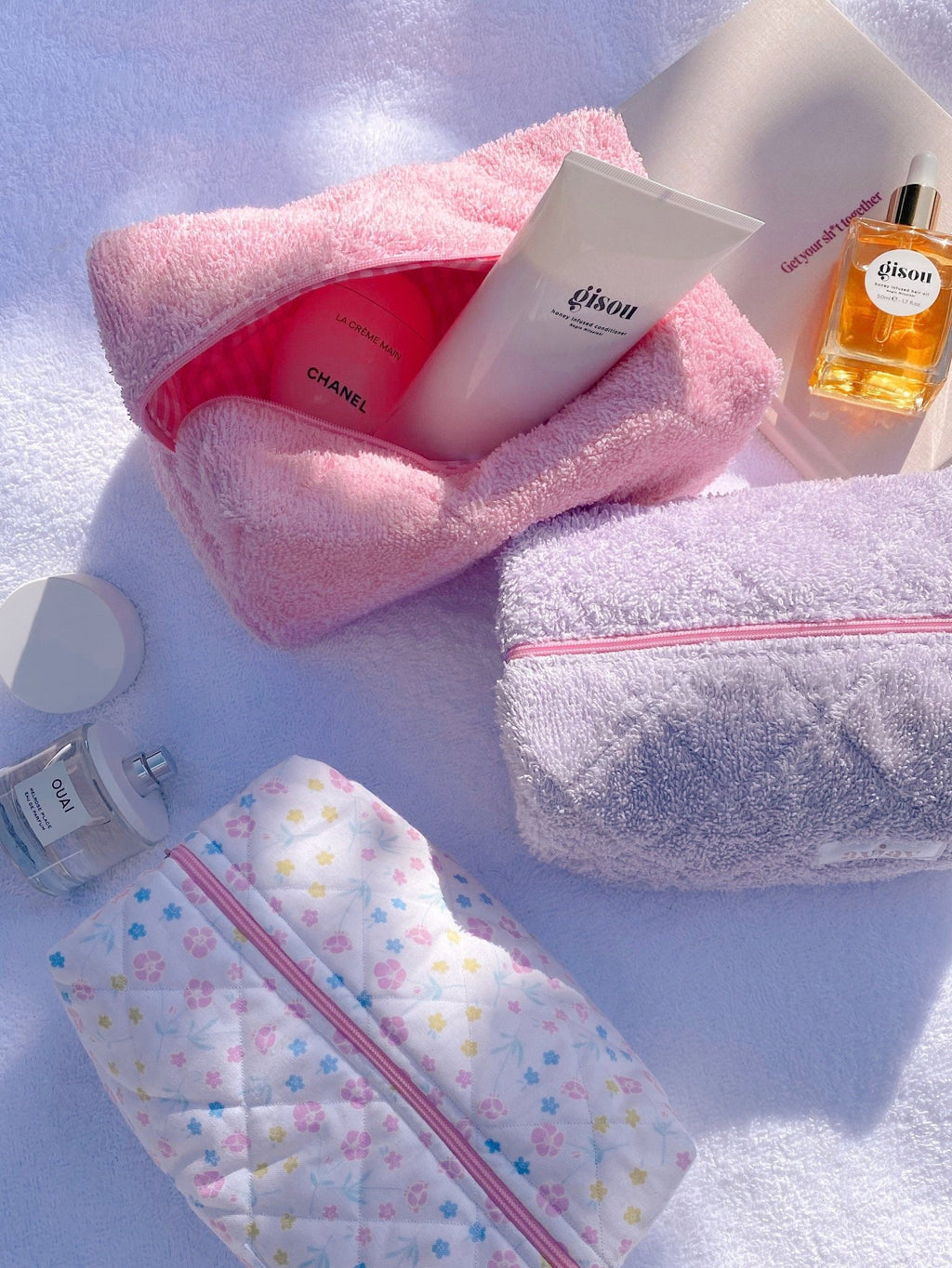 Pink terrycloth zip pouch and lavender terrycloth zip pouch, both open with visible lining