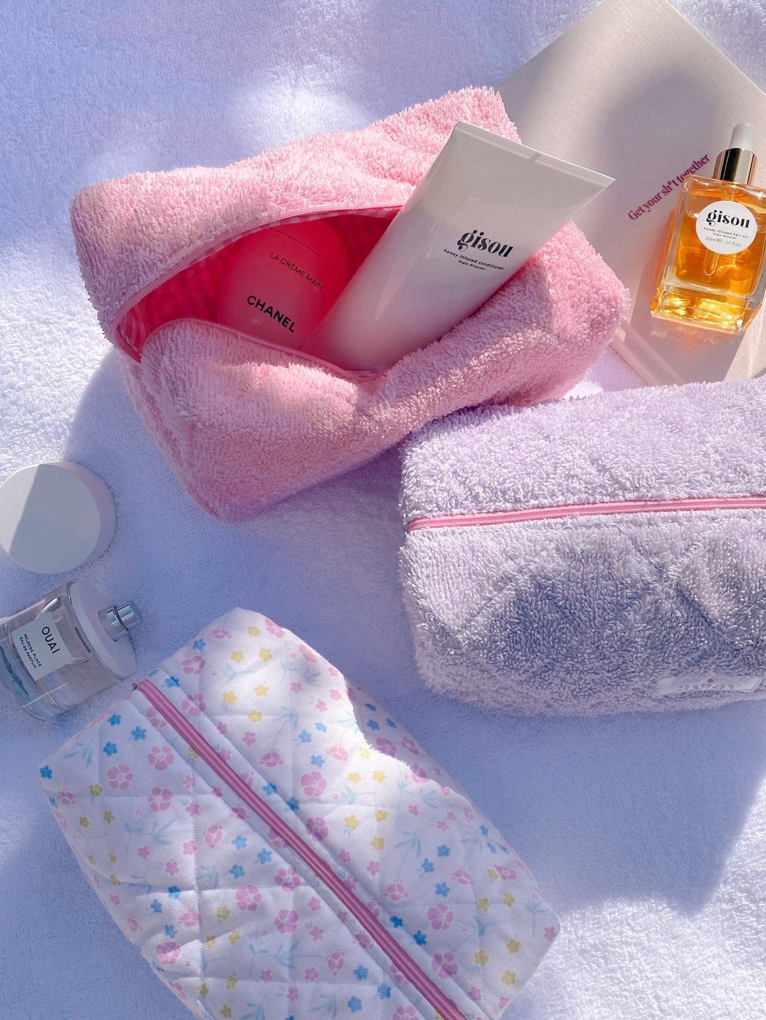 Pink terrycloth zip pouch and lavender terrycloth zip pouch, both open with visible lining