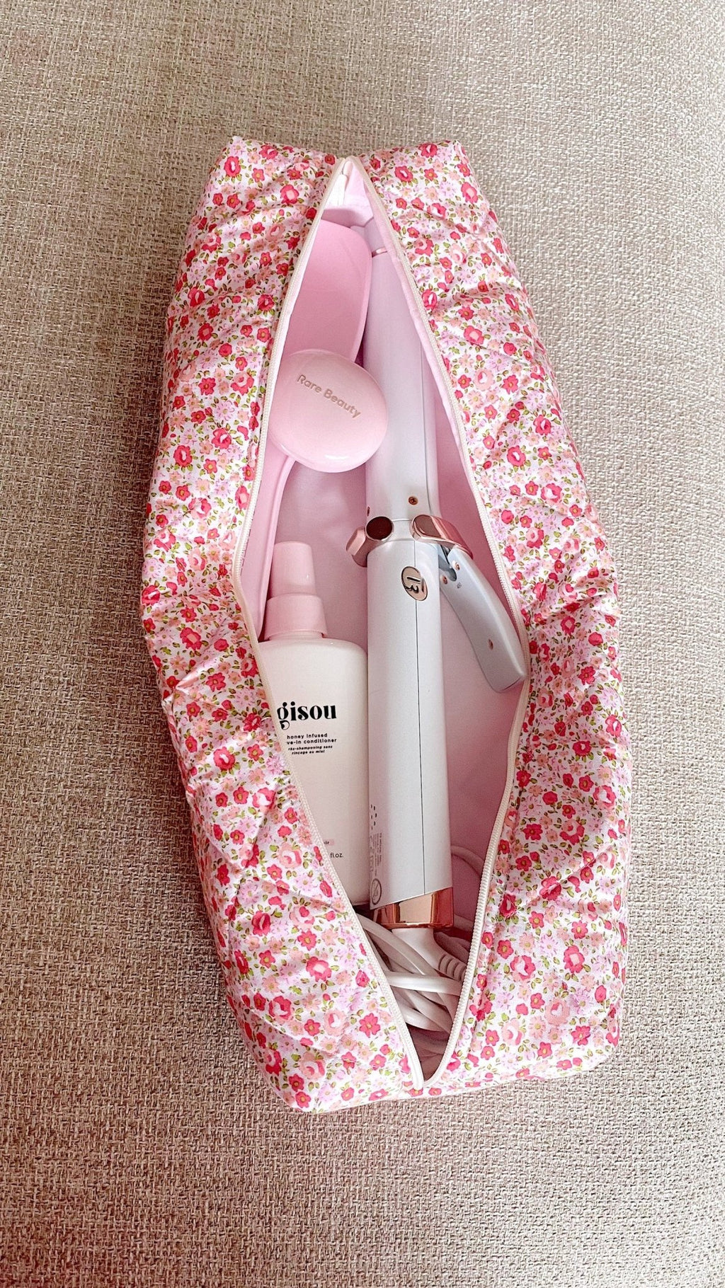 Floral zip pouch open, showing stacked tools and products inside
