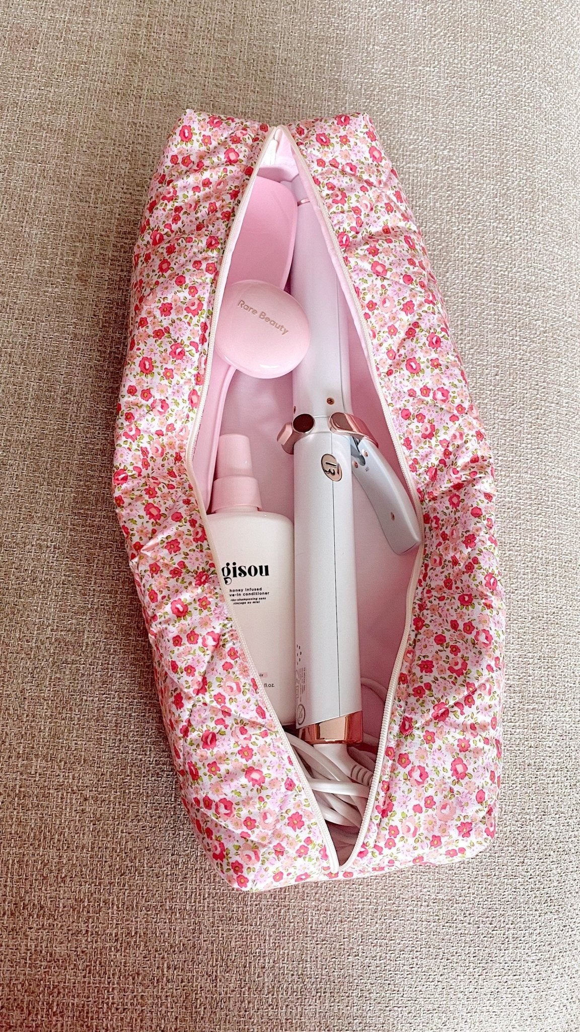 Floral zip pouch open, showing stacked tools and products inside