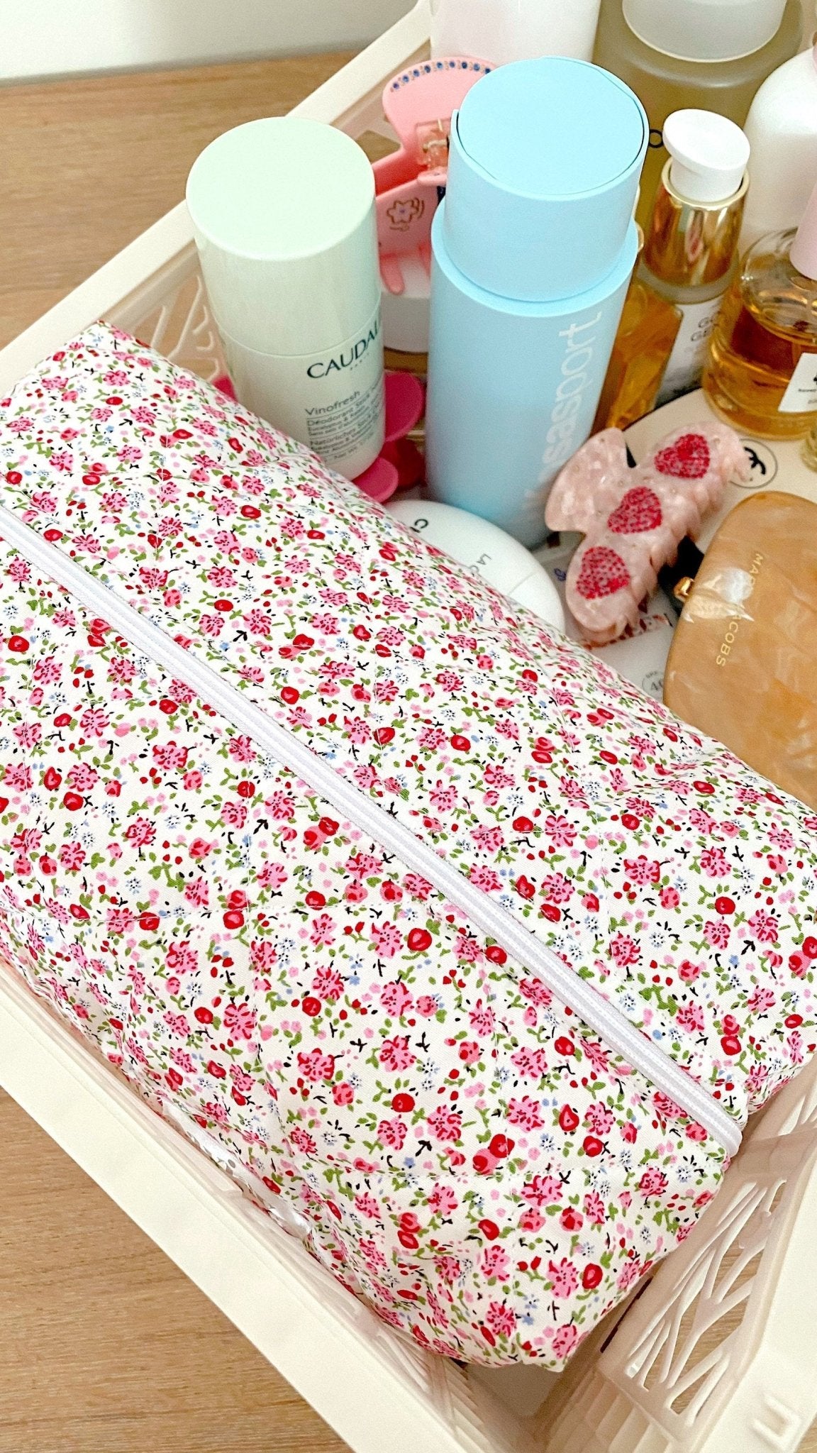 Long floral toiletry pouch with light trim and front zipper, shown partially filled.