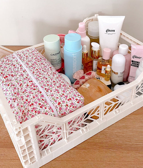 Floral zip toiletry bag in a white organizer tray, patterned exterior and front zipper.