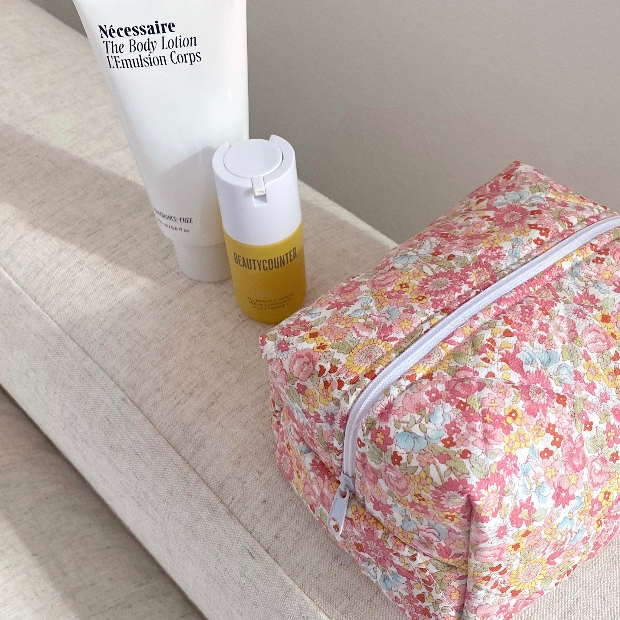 Floral toiletry pouch with zip closure and light-colored lining, side view