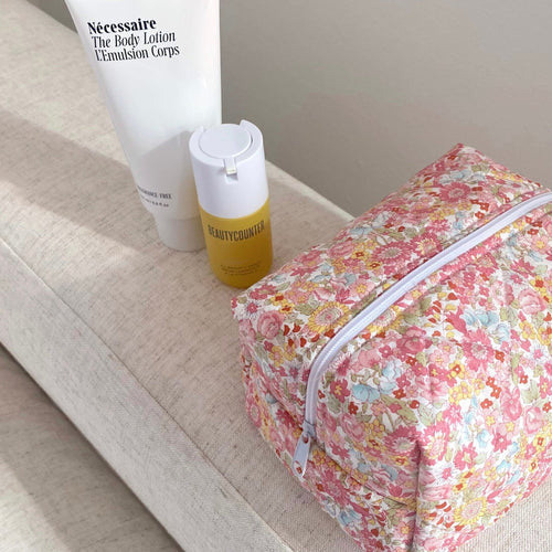 Floral toiletry pouch with zip closure and light-colored lining, side view