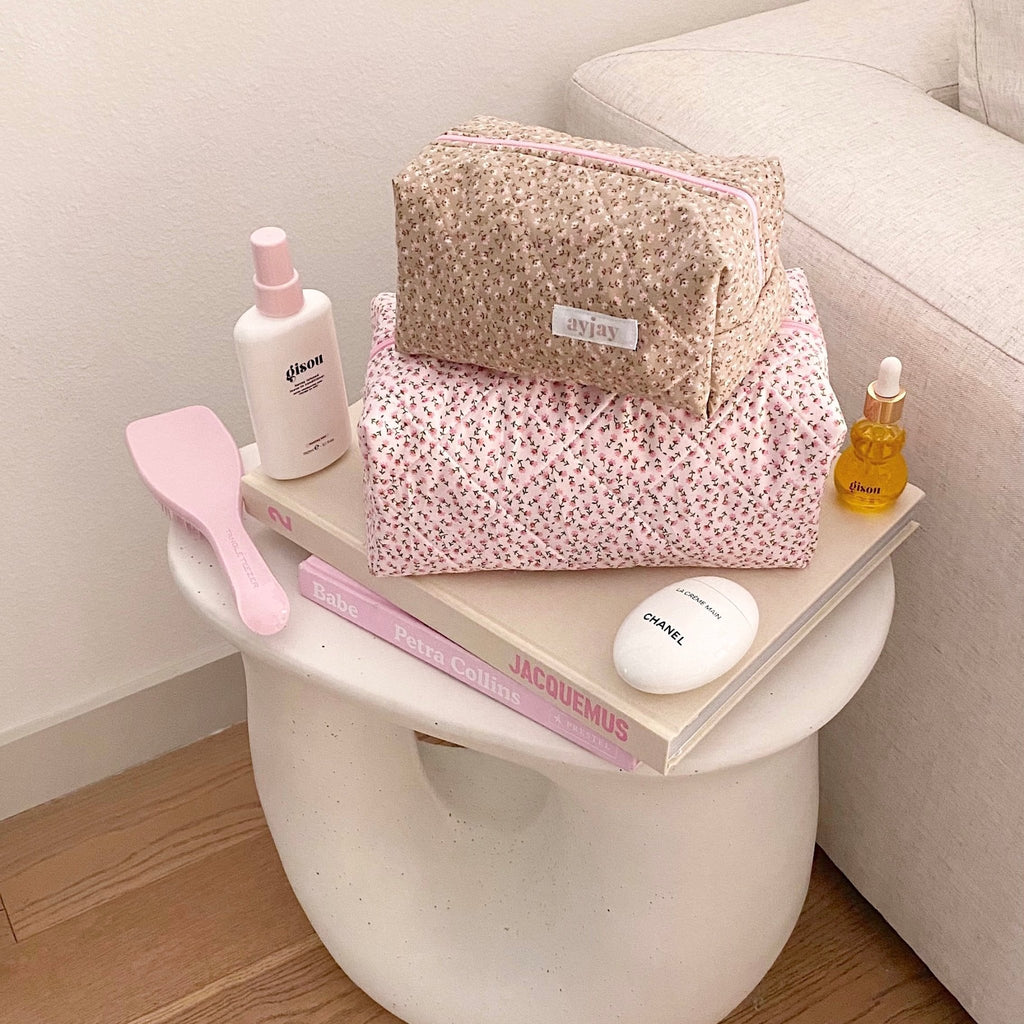 Tan ditsy floral cosmetic pouch with pink zipper trim and fabric label tab