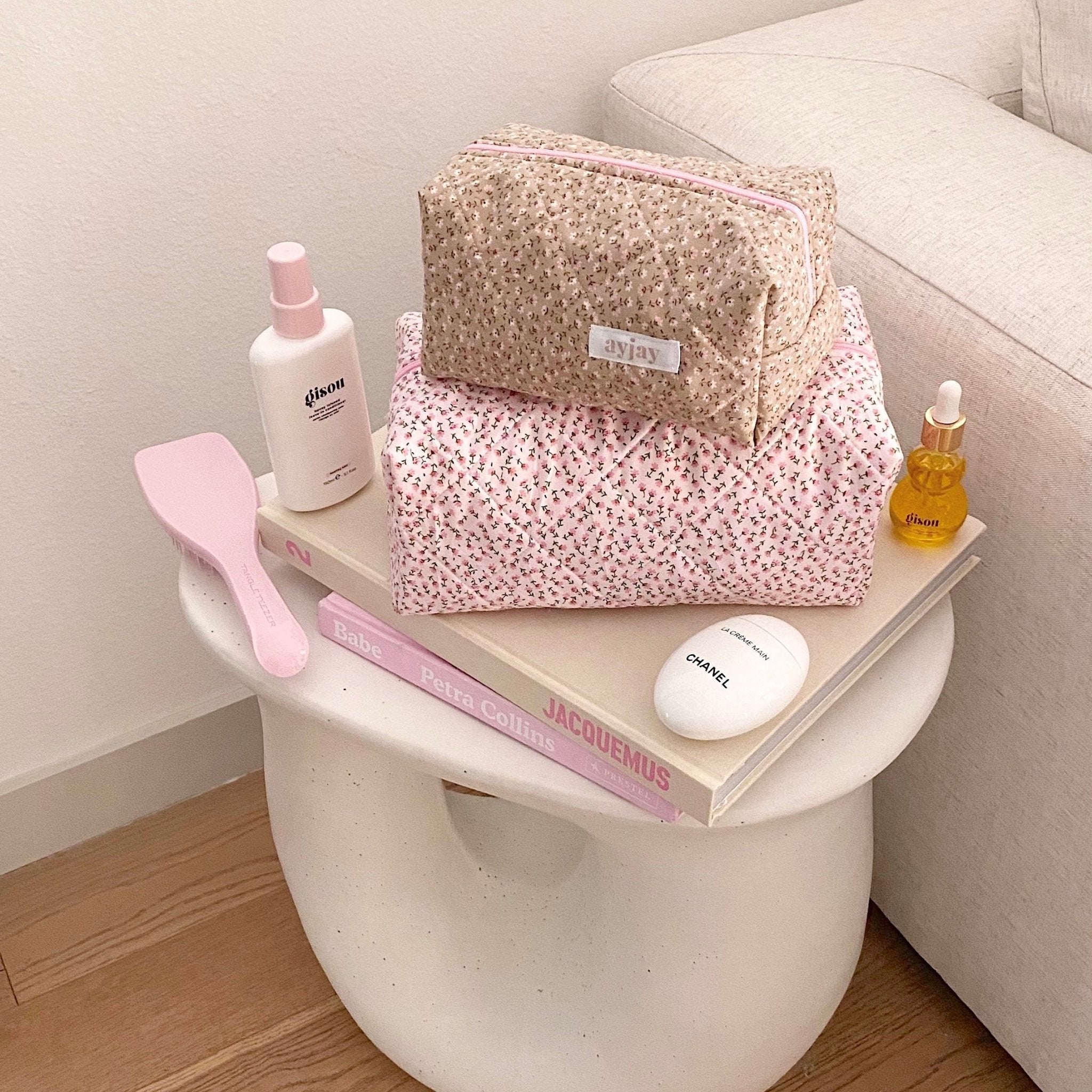 Tan ditsy floral cosmetic pouch with pink zipper trim and fabric label tab