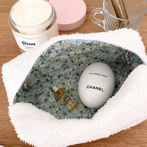 White terrycloth cosmetic pouch with mint-and-daisy floral lining and rounded opening