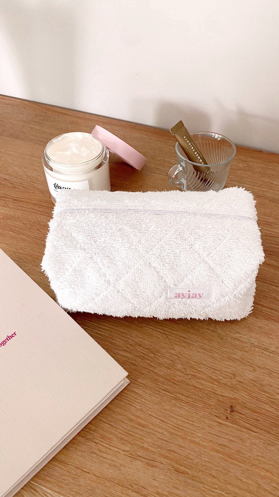 White terrycloth pouch with horizontal zip, front panel visible