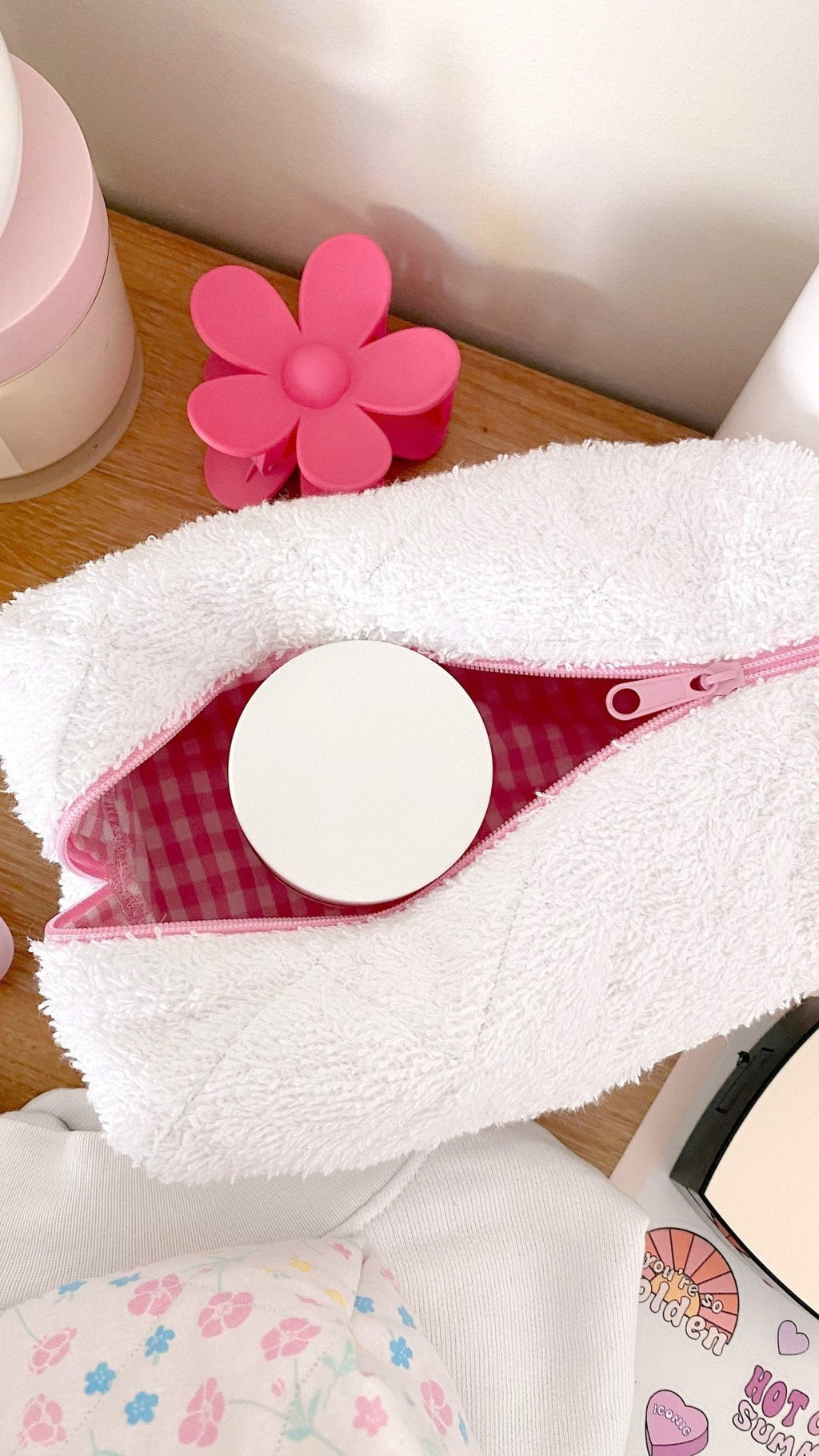 White terrycloth pouch with pink gingham interior, zipper partly open
