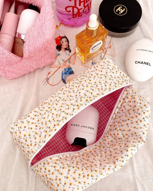 Floral zipper pouch open to show pink gingham lining inside, cream base